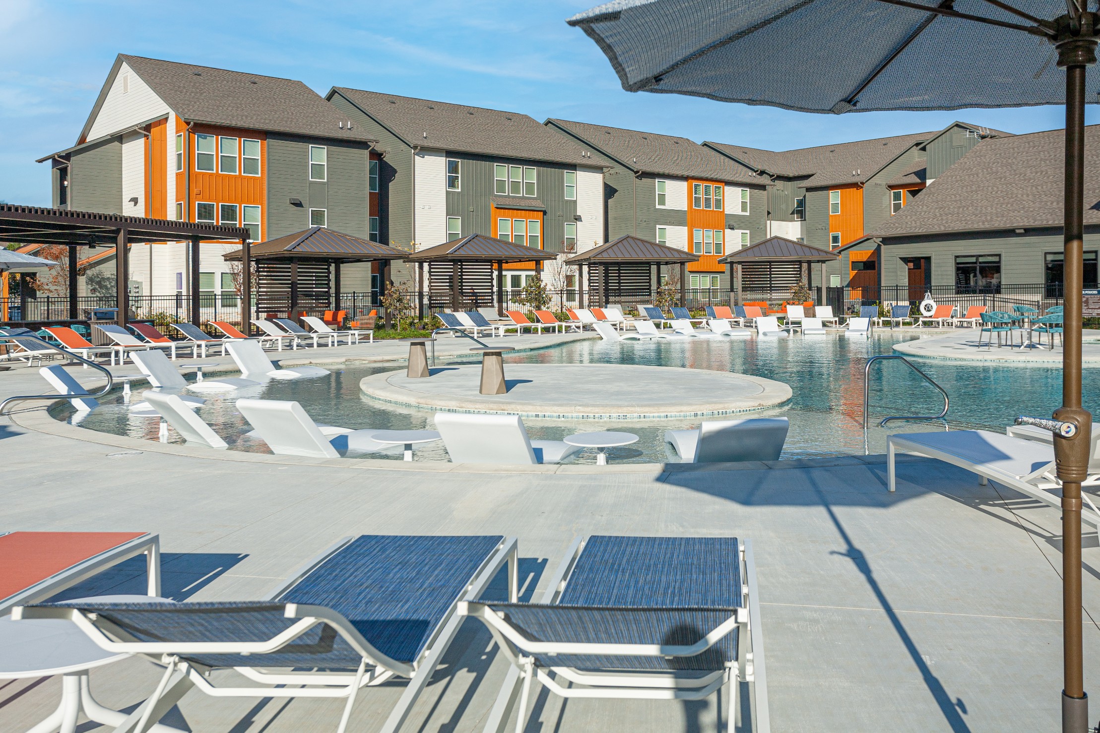 Resort style swimming pool with in pool lounge chairs at The Tusk
