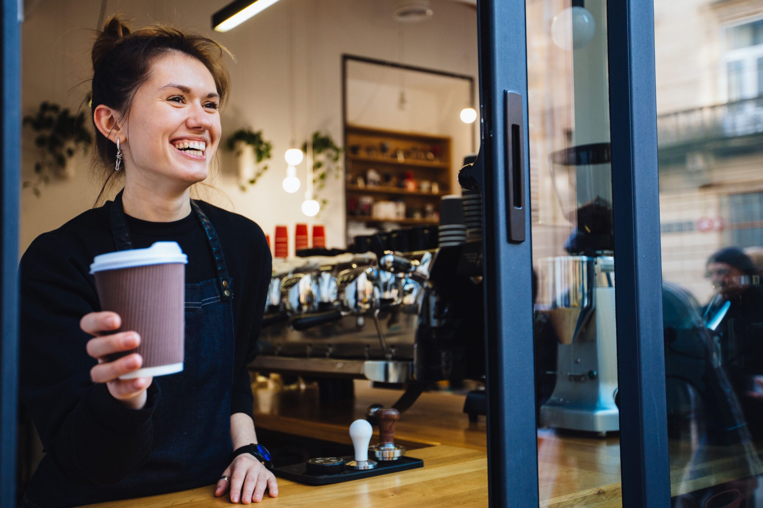 barista serving coffee through window scaled
